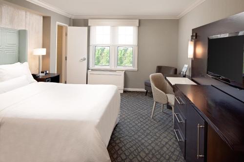 a hotel room with a bed and a desk and a television at The Westin Governor Morris, Morristown in Morristown