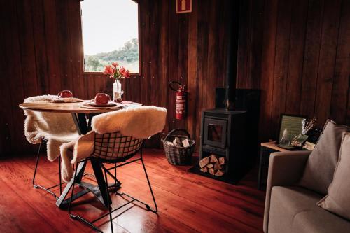 a living room with a table and a stove at Pipas Terroir & Domos Perlage - Experiências Únicas no Vale dos Vinhedos in Bento Gonçalves