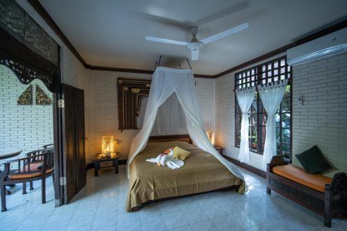 - une chambre avec un lit et une moustiquaire dans l'établissement Puri Bayu, à Ubud