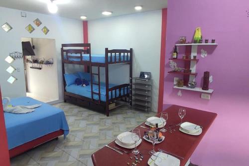 een kamer met 2 stapelbedden en een tafel met glazen bij Tortuga House in Puerto Baquerizo Moreno
