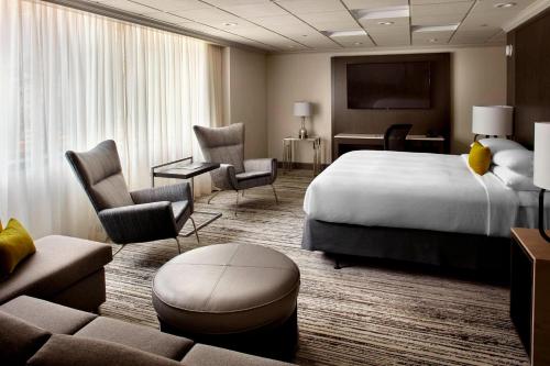 Habitación de hotel con cama, sillas y sofá en Marriott Cincinnati North, en West Chester