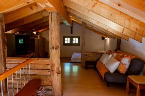 Habitación con altillo con cama y sofá en Chalet Edelweiss, en Hérémence
