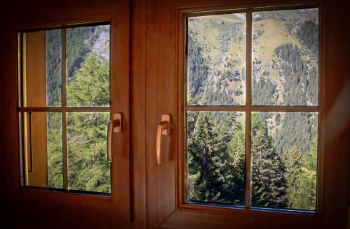 a window with a view of a mountain at Chalet Edelweiss in Hérémence