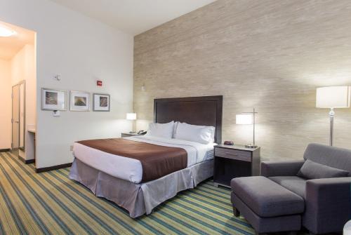a hotel room with a bed and a chair at Holiday Inn Texarkana Arkansas Convention Center by IHG in Texarkana