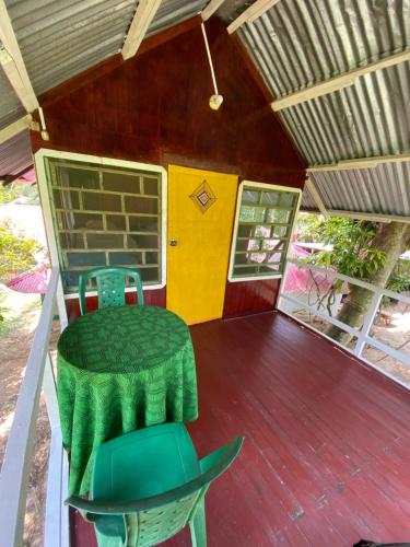 a green chair sitting on the porch of a house at Chaikoni Lodge in Pucallpa