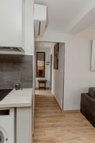 une cuisine et un salon avec des murs blancs et du parquet dans l'établissement Tokyo le magnifique T2, à Montauban