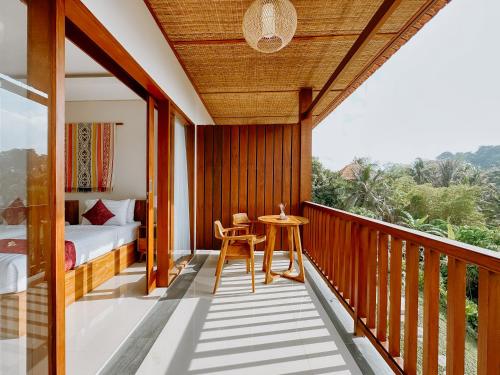 a room with a balcony with a bed and a table at Sanubari Ubud in Ubud