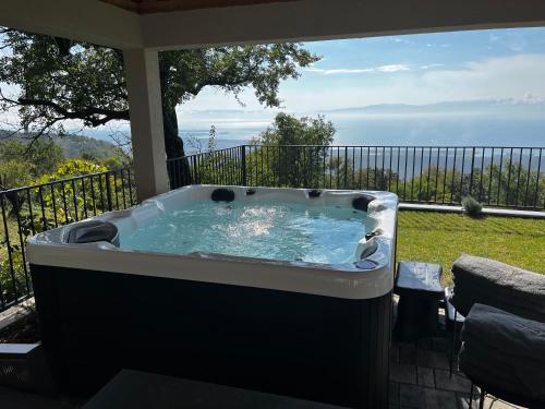 a hot tub on a patio with a view of the ocean at Villa Green Garden in Hreljin