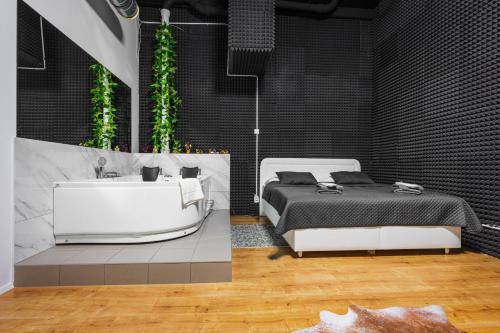 una camera con letto e vasca da bagno accanto di Wellness Apartman Vrakuna a Bratislava