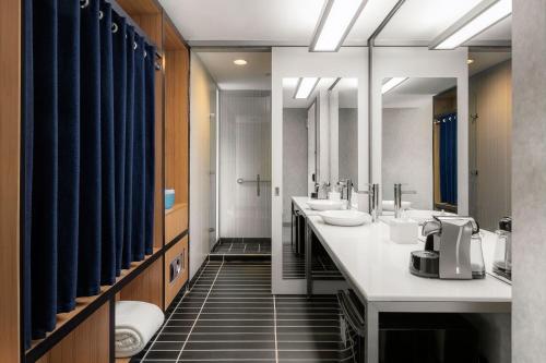 a bathroom with three sinks and three mirrors at Aloft Bogotá Airport in Bogotá