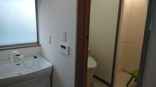 uma casa de banho com um lavatório branco e um WC. em Kōnotori no sato no yado Bekan - Vacation STAY 11543 em Kōnosu