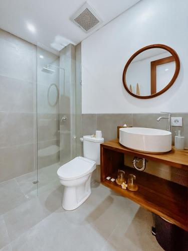 a bathroom with a toilet and a sink and a mirror at Sanubari Ubud in Ubud