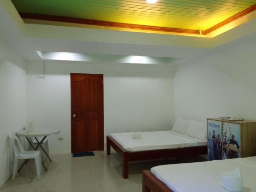 a room with a bed and a table and a yellow ceiling at LaVeranda Beach Resort in Dauis