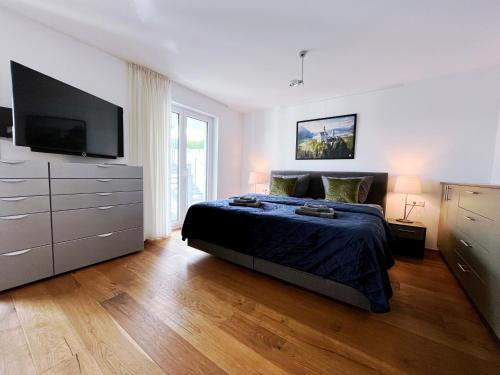 a bedroom with a bed and a flat screen tv at Luxuriöses 130qm Apartment mit Balkon im Zentrum,Parkplatz in Heilbronn