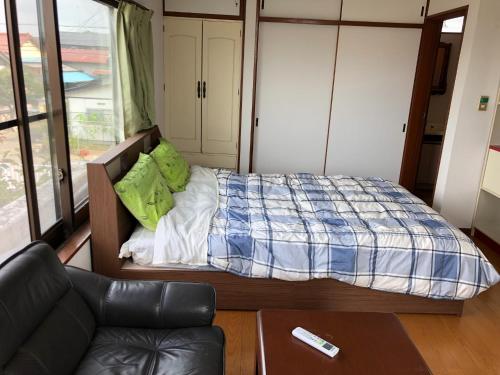 Kounotori no Sato no Yado - Vacation STAY 13076 في Kōnosu: غرفة نوم صغيرة مع سرير وأريكة