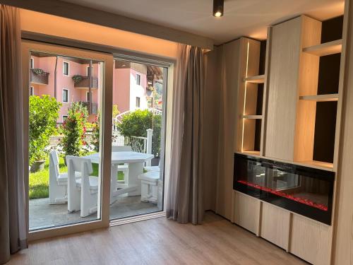 a living room with a sliding glass door leading to a patio at ROSENSUITE La Residenza del rosengarten in Pinzolo