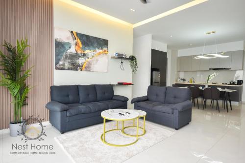 a living room with two blue couches and a table at Country Garden Seaview Suite by Nest Home at Danga Bay in Johor Bahru