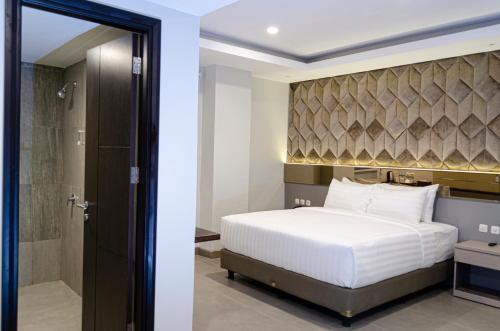 a bedroom with a king sized bed and a shower at Arcadia Hotel Manado in Manado