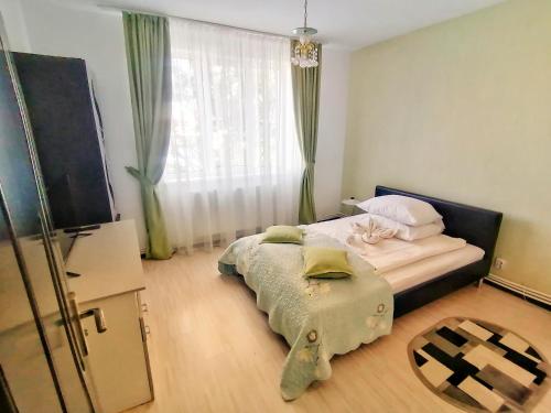 a small bedroom with a bed and a window at Apartament Anita in Vulcan