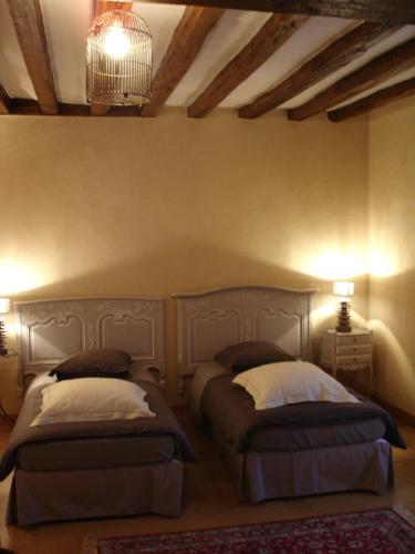 une chambre avec deux lits et un lustre dans l'établissement Chambres d'Hôtes La Bosquetière, à Maresché