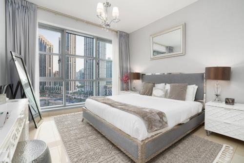a bedroom with a large bed and a large window at Ultimate Stay 2 BR Next to Burj Khalifa with Opera & Fountain Views in Dubai