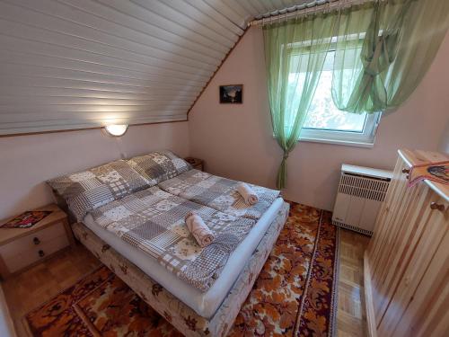 um pequeno quarto com uma cama no sótão em Alina vendégház em Mezőkövesd