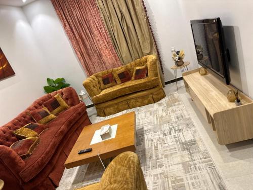 a living room with two couches and a television at Luxury apartment in a tower شقه فاخرة في برج اللؤلؤة in Riyadh