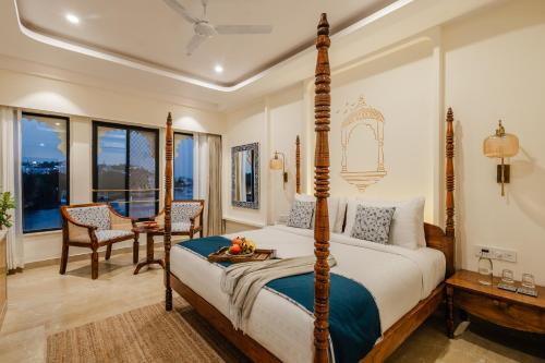 a bedroom with a bed and a table and chairs at The Experience Resort-Lake Facing in Udaipur