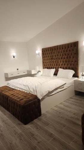 um quarto com uma cama grande e uma grande cabeceira. em شاليه ومنتجع النخيل الريفي بالطائف em As Sayl aş Şaghīr