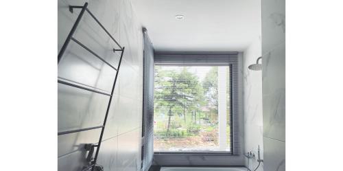 a bathroom with a window and a shower and a sink at Dear house Homestay in Puli