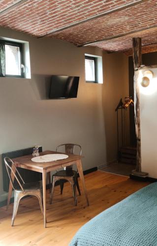 une salle à manger avec une table et deux chaises dans l'établissement Coeur de ferme en Pévèle, à Attiches