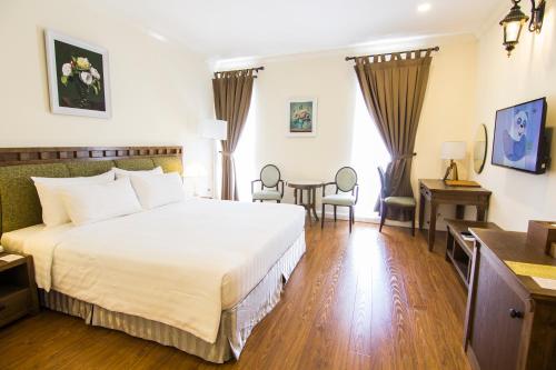 a hotel room with a bed and a table at Phoenix Hotel Vung Tau in Vung Tau