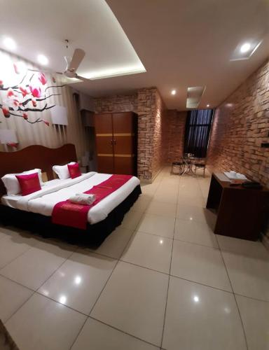a bedroom with a large bed and a brick wall at The mirage in Ludhiana