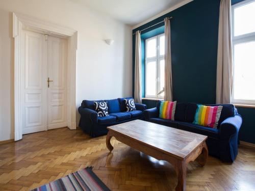 クラクフにあるAiry and sunny apartment in the centre of Krakowのリビングルーム(青いソファ2台、コーヒーテーブル付)