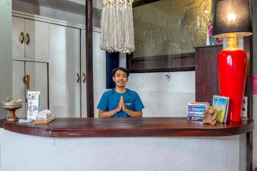 a man is standing behind a bar with his hands up at Bamboo Paradise in Padangbai