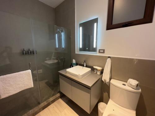 La salle de bains est pourvue de toilettes, d'un lavabo et d'une douche. dans l'établissement L2A 205 - Boutique apartamento en Cayalá para 5 huéspedes, à Guatemala