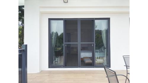 a glass door on a white house with two chairs at Dear house Homestay in Puli