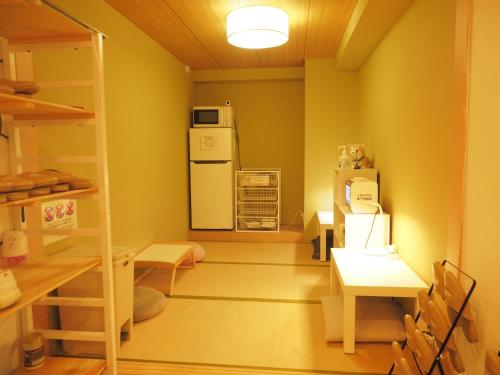 a room with a refrigerator and a table and chairs at bnb+ Akihabara (Female Only) in Tokyo