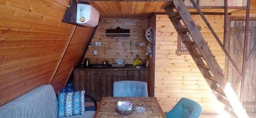 una habitación con mesa y sillas en una cabaña en Fairytale Aframe House en Quba