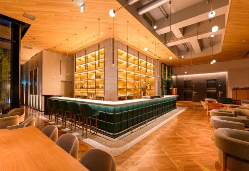 a restaurant with a bar and tables and chairs at THE KNOT HIROSHIMA in Hiroshima