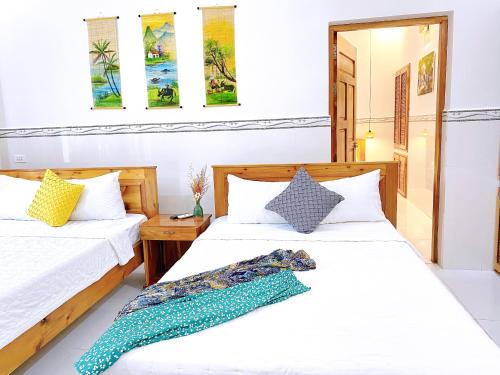 two beds in a room with white walls at Have Fun Phú Quốc in Phú Quốc