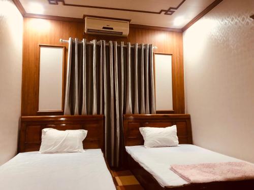 um quarto com duas camas e uma cortina em Nhà Nghỉ Đại Dương tắm khoáng nóng Mỹ Lâm em Ho Tô