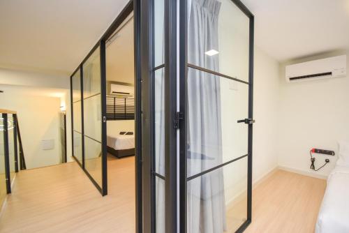 a glass door in a room with a bedroom at Sunway Grid Loft Suite by Nest Home【Olympic Size Pool】 in Kampong Pendas