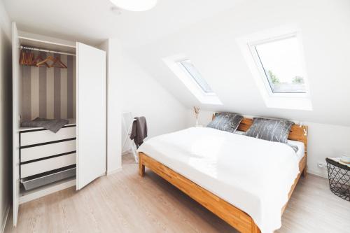 a white bedroom with a bed and a closet at Casa Ueberall in Fehmarn