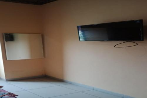 esquina de una habitación con TV de pantalla plana en la pared en OYO Life 90646 Villa Karsinem Pasuruan en Pasuruan