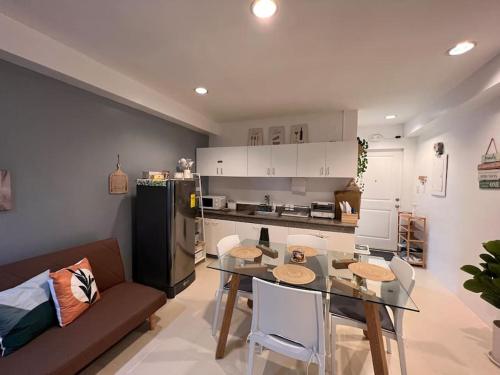 Charm’s Place في اولونجابو: مطبخ وغرفة معيشة مع طاولة وأريكة