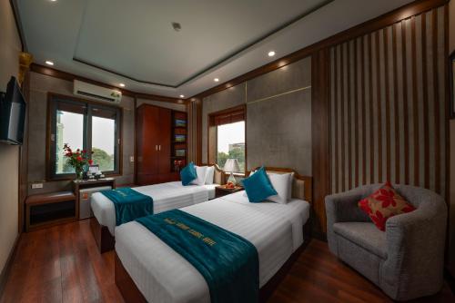 um quarto de hotel com duas camas e uma cadeira em Hanoi Airport Hotel - Convenient & Friendly em Noi Bai