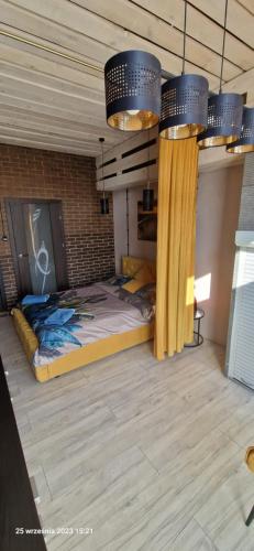 een bed in een kamer met 2 kroonluchters bij WILLA VASCO BOSMAN in Rewa