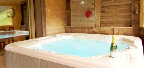 a jacuzzi tub with a bottle of wine in it at Chalet Les Lanchettes in Morzine
