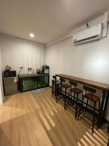 a room with a bar with stools and a kitchen at 22 Hours Hostel in Kampong Gadong
